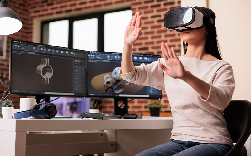 A woman immersed in virtual reality, wearing a headset, while seated at her desk.